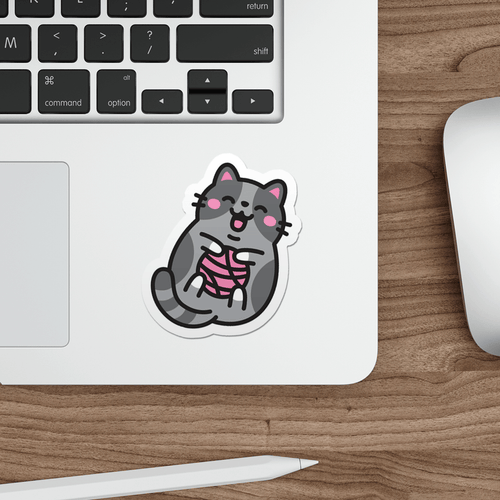 Laptop with a sticker of a cute grey cat with a pink ball of yarn on a wooden desk.