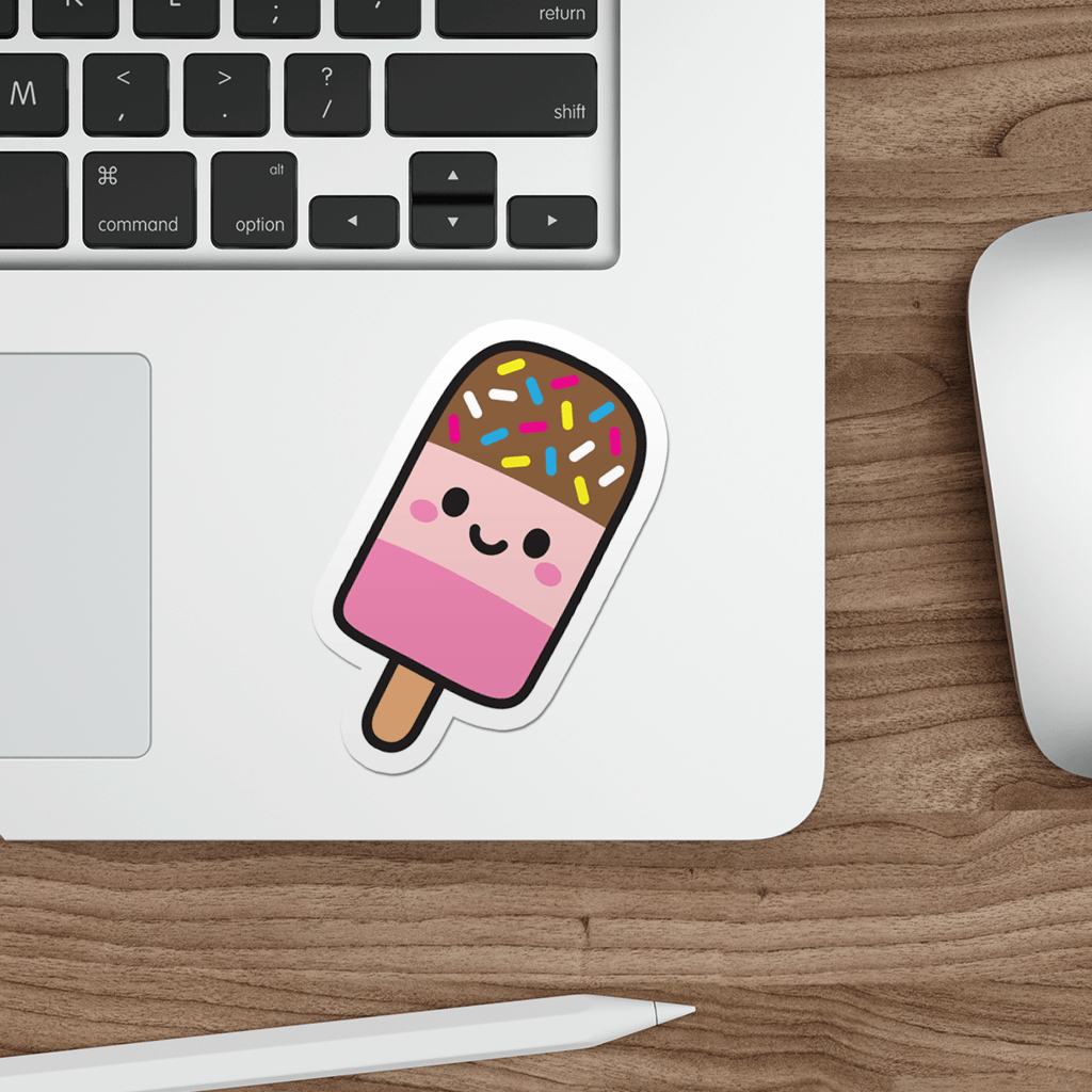 Laptop with a die-cut vinyl sticker of a cute fab lolly on a wooden desk.