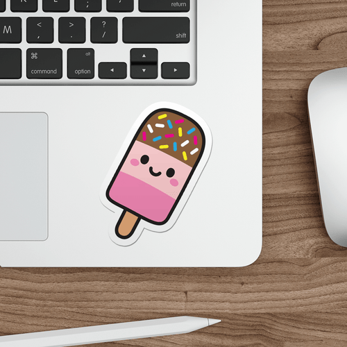 Laptop with a die-cut vinyl sticker of a cute fab lolly on a wooden desk.