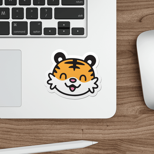 Laptop with a sticker of a kawaii tiger face on a wooden desk.