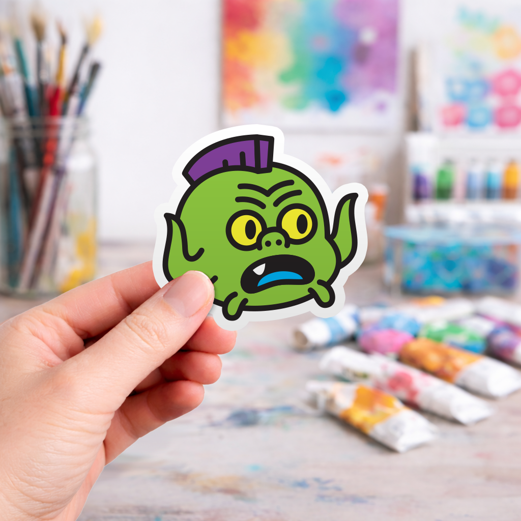 Hand holding a colorful laptop sticker of a cartoon ninja turtle character