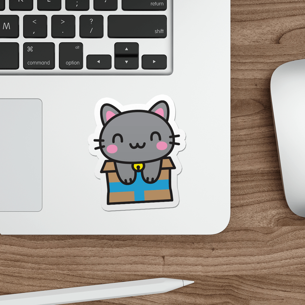 Laptop with a sticker of a kawaii grey cat in a box on a wooden desk.
