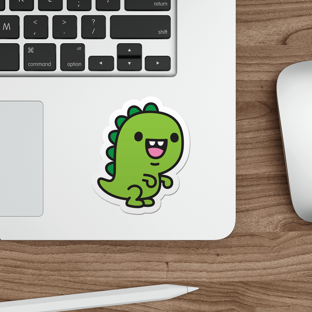 Laptop with a die-cut vinyl sticker of a kawaii t-rex dinosaur on a wooden desk.