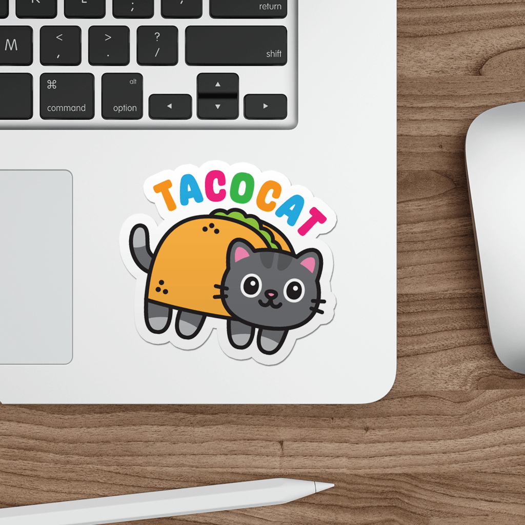 Laptop with a sticker of a tacocat on a wooden desk.