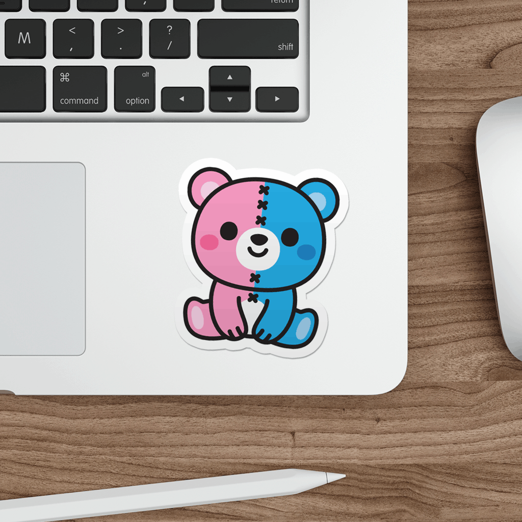 Sticker of a pink and blue bear on a laptop on a wooden desk