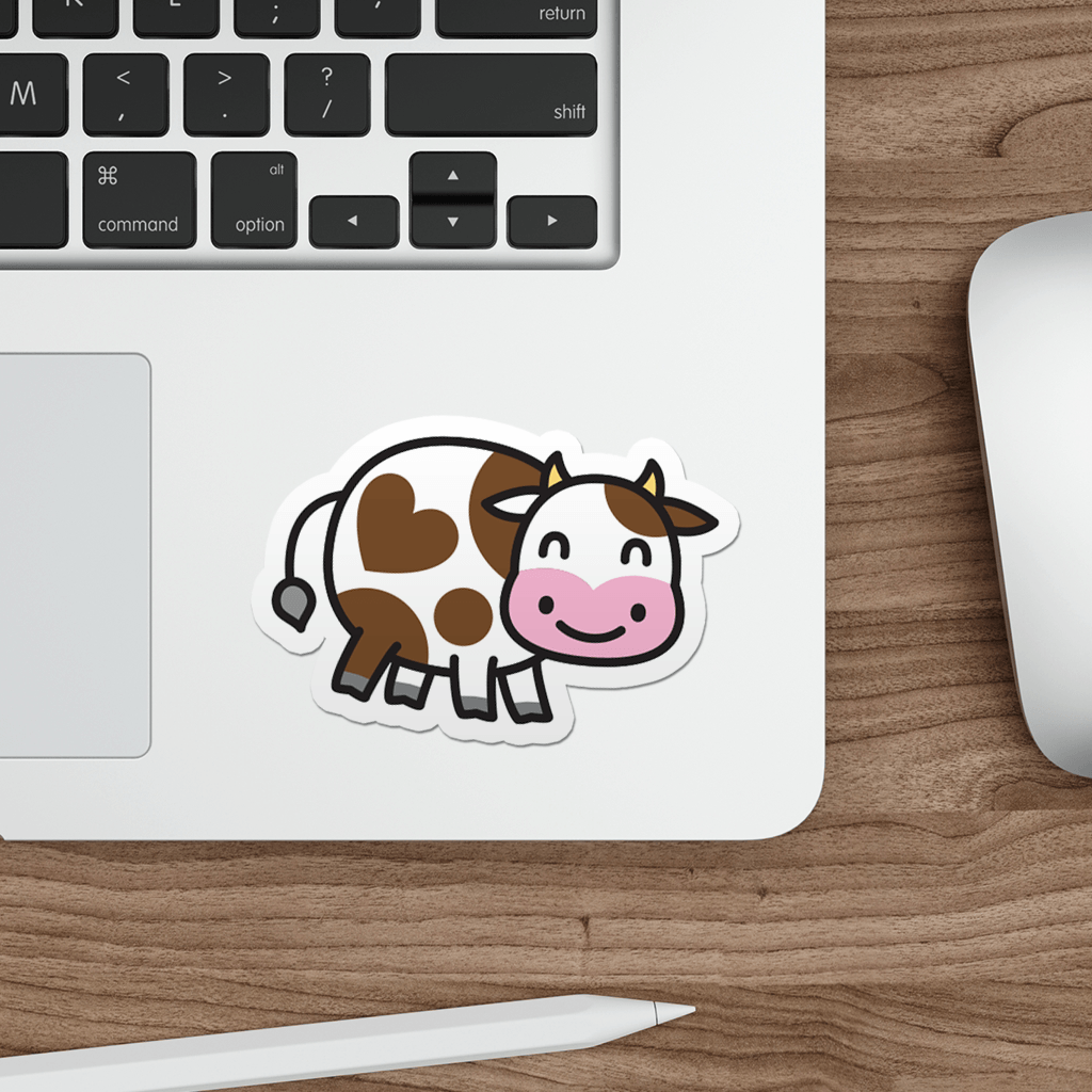 Laptop with a cow sticker on a wooden desk