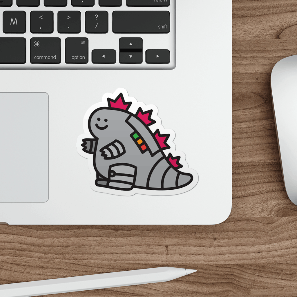 Laptop with a sticker of a cute mechagodzilla on a wooden desk.